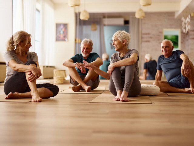 Happy athletic seniors talking on a break in a health club.